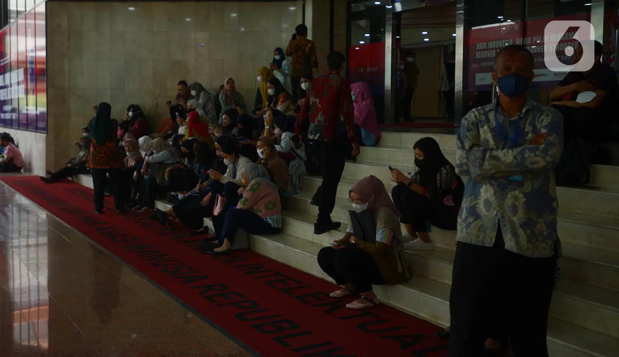 Pegawai berhamburan di luar Gedung Kemenkumham saat terjadi kebakaran, Jakarta, Kamis (8/12/2022). Api mulanya muncul di lantai 5 di mana tempat itu merupakan gudang administrasi arsip sekretariat. (merdeka.com/Imam Buhori)