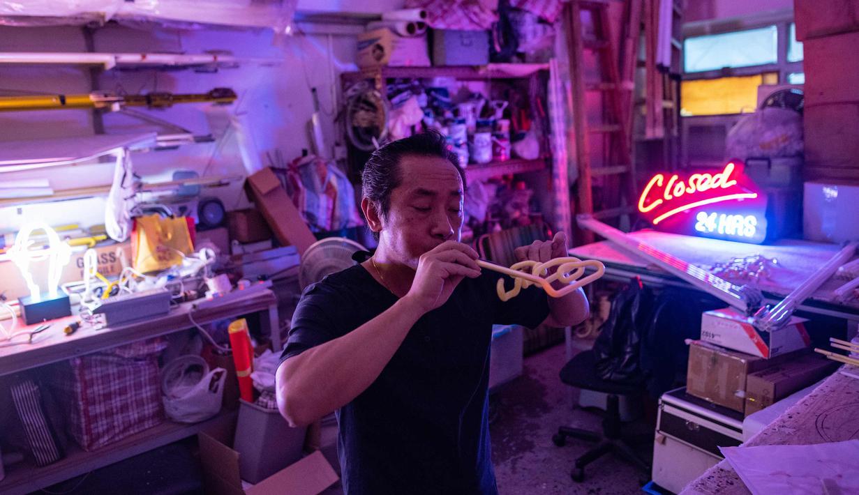 Wu Chi-kai mendemonstrasikan bagaimana membuat neon sign selama wawancara dengan AFP di Hong Kong (16/4). Wu Chi-kai merupakan salah satu pengrajin neon sign yang tersisa dari jenisnya di Hong Kong. (AFP Photo/Philip Fong)