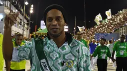 Ronaldinho Gaucho saat menghadiri malam kedua Karnaval Samba di Sambadrome, Rio de Janeiro, Brasil (28/2). Parade karnaval tahunan ini menampilkan aksi para penari-penari seksi dari sejumlah sekolah samba di Brasil. (AFP Photo / Vanderlei Almeida)