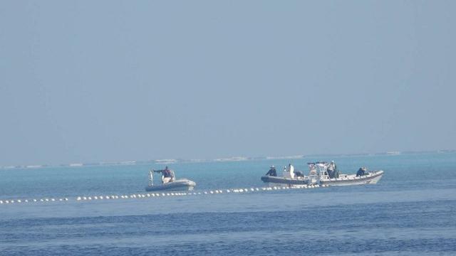 Gambar menunjukkan penghalang terapung dijaga oleh kapal China di wilayah yang dikenal di Filipina sebagai Bajo de Masinloc di Laut China Selatan. (Dok. Philippine Coast Guard)