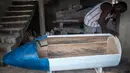 Pekerja menyelesaikan peti mati berbentuk pena di Hello Design Works Coffin, Ibu Kota Ghana, 10 Oktober 2016. Sejak puluhan tahun, masyarakat Kota Accra memesan peti mati yang melambangkan kehidupan orang yang sudah meninggal. (Stefan HEUNIS/AFP)