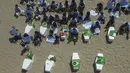14 peti mati diletakkan di pantai Copacabana untuk mewakili 14 anak, berusia 0 hingga 14 tahun, yang terbunuh antara tahun 2022 dan 2023 di negara bagian Rio, baik dalam tindakan polisi maupun dalam bentrokan antara penjahat yang saling bersaing. (AP Photo/Bruna Prado)