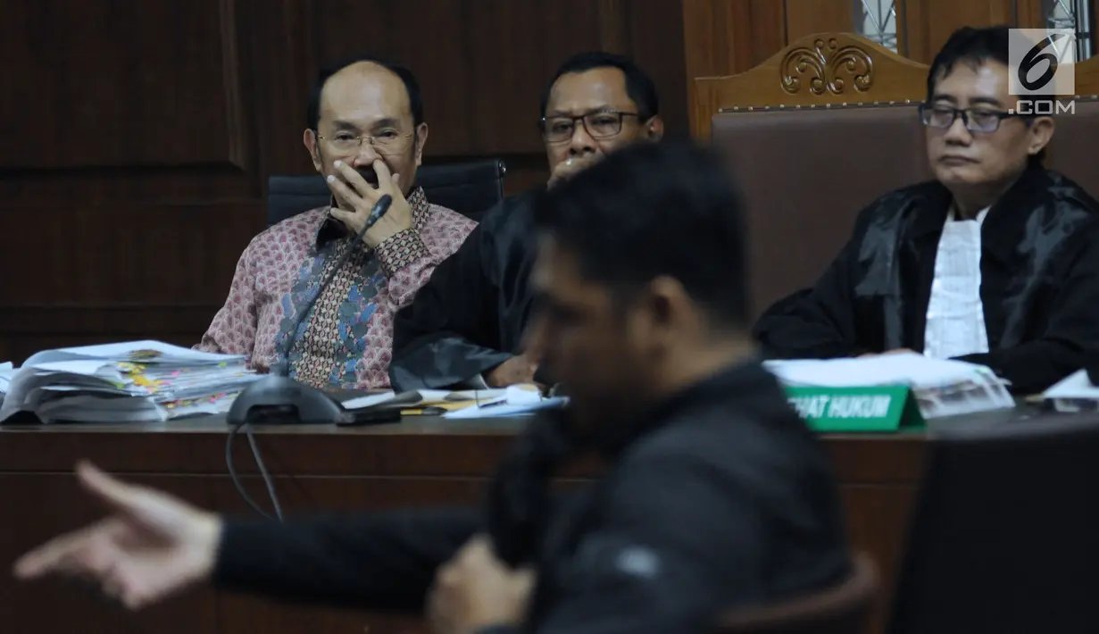 Terdakwa kasus merintangi penyidikan dugaan korupsi e-KTP, Fredrich Yunadi (kiri) menymak keterangan stafnya pada sidang lanjutan di Pengadilan Tipikor, Jakarta, Kamis (12/4). Sidang mendengar keterangan saksi. (Liputan6.com/Helmi Fithriansyah)