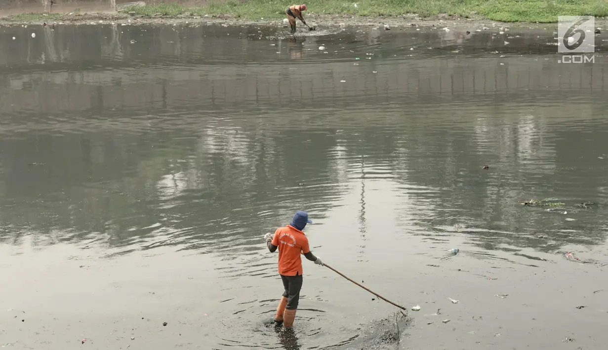 Dua pekerja membersihkan sampah yang mengotori aliran Kanal Banjir Timur (KBT), Jakarta, Sabtu (15/9). Banyaknya limbah rumah tangga dan limbah industri menyebabkan kanal pengendali banjir tersebut selalu tercemari sampah. (Liputan6.com/Immanuel Antonius)