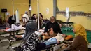 Murid-murid sekolah dasar mendapatkan perawatan di klinik darurat setelah mengalami keracunan usai menyantap makanan yang dibagikan lewat program Makan Bergizi Gratis di Bandung, Jawa Barat, pada 23 September 2025. (Timur Matahari/AFP)