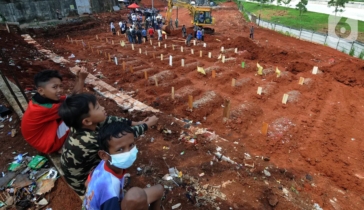 Anak-anak berada di lahan baru Tempat Pemakaman Umum (TPU) khusus COVID-19, Jombang, Tangerang Selatan, Banten,Senin (26/7/2021). Pembukaan lahan baru TPU khusus COVID-19 dikarenakan tingginya angka kematian COVID-19 di wilayah tersebut. (merdeka.com/Arie Basuki)