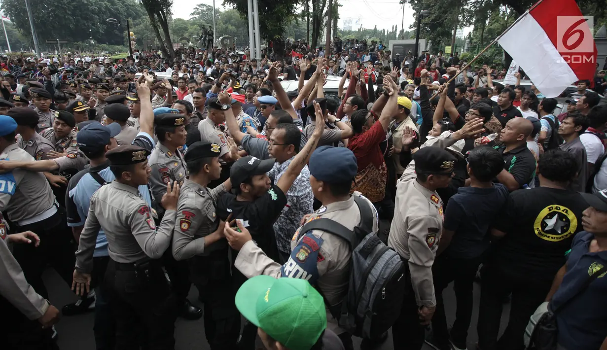 Demonstran driver online saling dorong dengan pihak kepolisian saat unjuk rasa di depan Istana Negara, Jakarta, Rabu (14/2). Kericuhan nyaris terjadi lantaran demonstran mencegat para driver online yang masih beroperasi. (Liputan6.com/Arya Manggala)