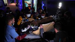 Petugas medis mengangkut Sham Sheikh Mohammed ke ambulans di perbatasan Bab al-Hawa pada 23 Februari 2023, sebelum memasuki Turki untuk perawatan. Sham, seorang gadis Suriah berusia sembilan tahun yang nasibnya menangkap tragedi, harapan dan patah hati gempa bulan ini setelah menghabiskan 40 jam di bawah reruntuhan dibawa ke Turki untuk dirawat. (AFP/OMAR HAJ KADOUR)