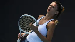 Petenis Italia, Camila Giorgi, memegang raket saat melawan petenis Jerman, Antonia Lottner, pada laga Australia Open di Melbourne, Selasa (21/1). (AFP/Greg Wood)