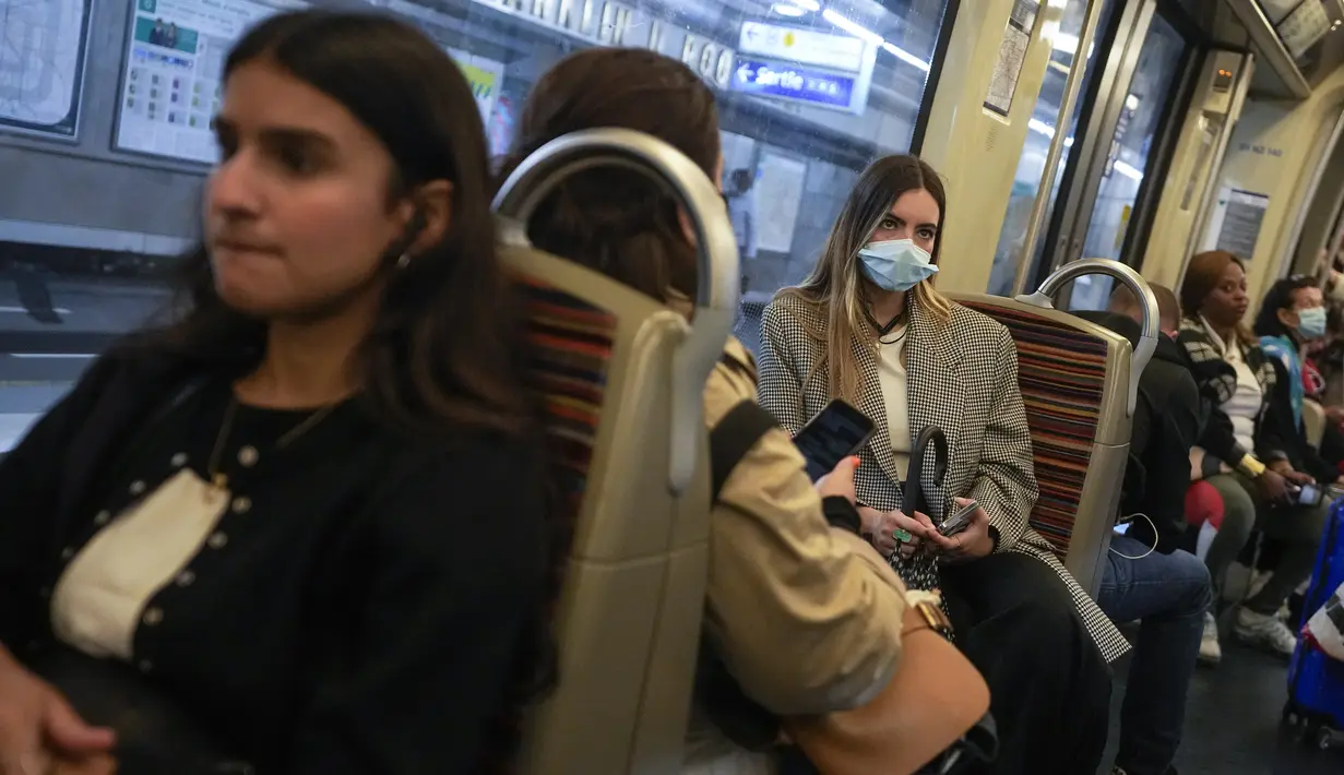Seorang perempuan yang mengenakan masker menaiki kereta bawah tanah di Paris, Prancis, Kamis (30/6/2022). Dengan turis memadati Paris dan kota-kota lain, pemerintah Prancis merekomendasikan untuk kembali mengenakan masker di transportasi umum dan area ramai tetapi tidak memberlakukan aturan baru. (AP Photo/Michel Euler)