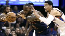 Pebasket Cleveland Cavaliers, LeBron James, berusaha melewati pebasket Oklahoma City Thunder, Andre Roberson. Pada laga ini Cavs kalah 109-118 dari Oklahoma. (EPA/Larry W.Smith)