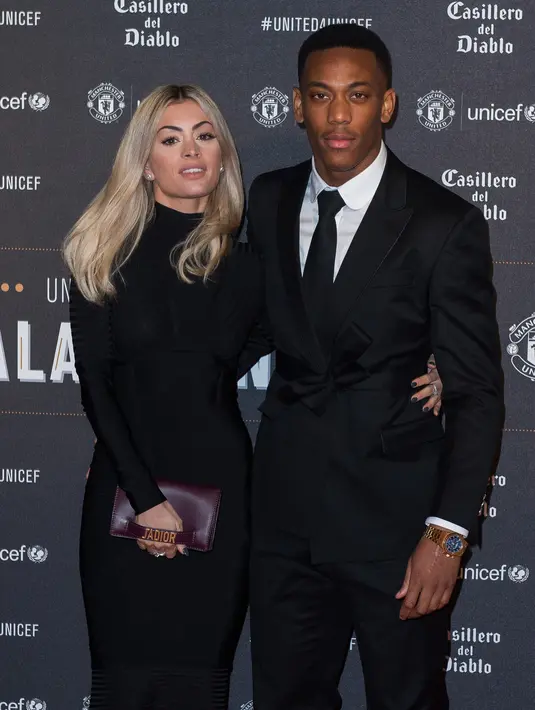 Striker Manchester United, Anthony Martial menggandeng kekasihnya Melanie Da Cruz di karpet merah makan malam acara amal UNICEF di Old Trafford, Rabu (15/11). Event ini sekaligus ajang pamer istri dan kekasih (WAGs) pasukan Red Devils. (Paul ELLIS/AFP)