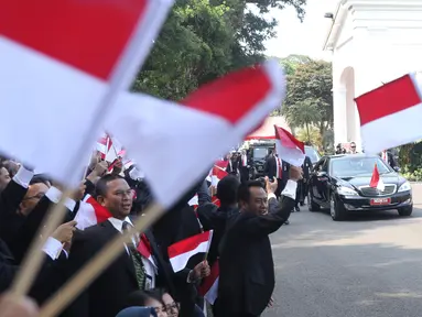 Pegawai Istana mengibarkan bendera merah putih saat rombongan mobil Presiden terpilih Joko Widodo (Jokowi)  melintas menuju gedung DPR di Istana Kepresidenan, Jakarta, Minggu (20/10/2019). Jokowi-Ma'ruf Amin kembali dilantik sebagai Presiden-Wapres RI periode 2019-2024. (Liputan6.com/Angga Yuniar)