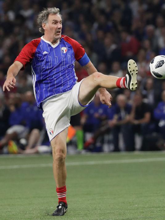 Bek Laurent Blanc berusaha mengontrol bola saat pertandingan tim Prancis 98 dengan tim FIFA 98 di Arena U, Nanterre, Paris (12/6). Pertandingan ini memperingati 20 tahun kemenangan Prancis di Piala Dunia 1998. (AFP Photo/Thomas Samson)