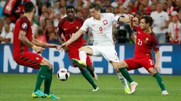 Penyerang Polandia, Robert Lewandoski (tengah) berusaha melewati para pemain Portugal pada perempat final Piala Eropa di Stade Velodrome, Perancis, (1/7). Portugal melaju ke Semifinal usai menang adu penalti dengan skor 5-3. (REUTERS / Yves Herman)