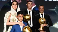 Georgina Rodriguez foto bersama kekasihnya Cristiano Ronaldo, putranya Cristiano Jr dan agen, Jorge Mendes diatas panggung selama Dubai Globe Soccer Awards ke-10 di Dubai (3/1). (AFP Photo/Fabio Ferrari)