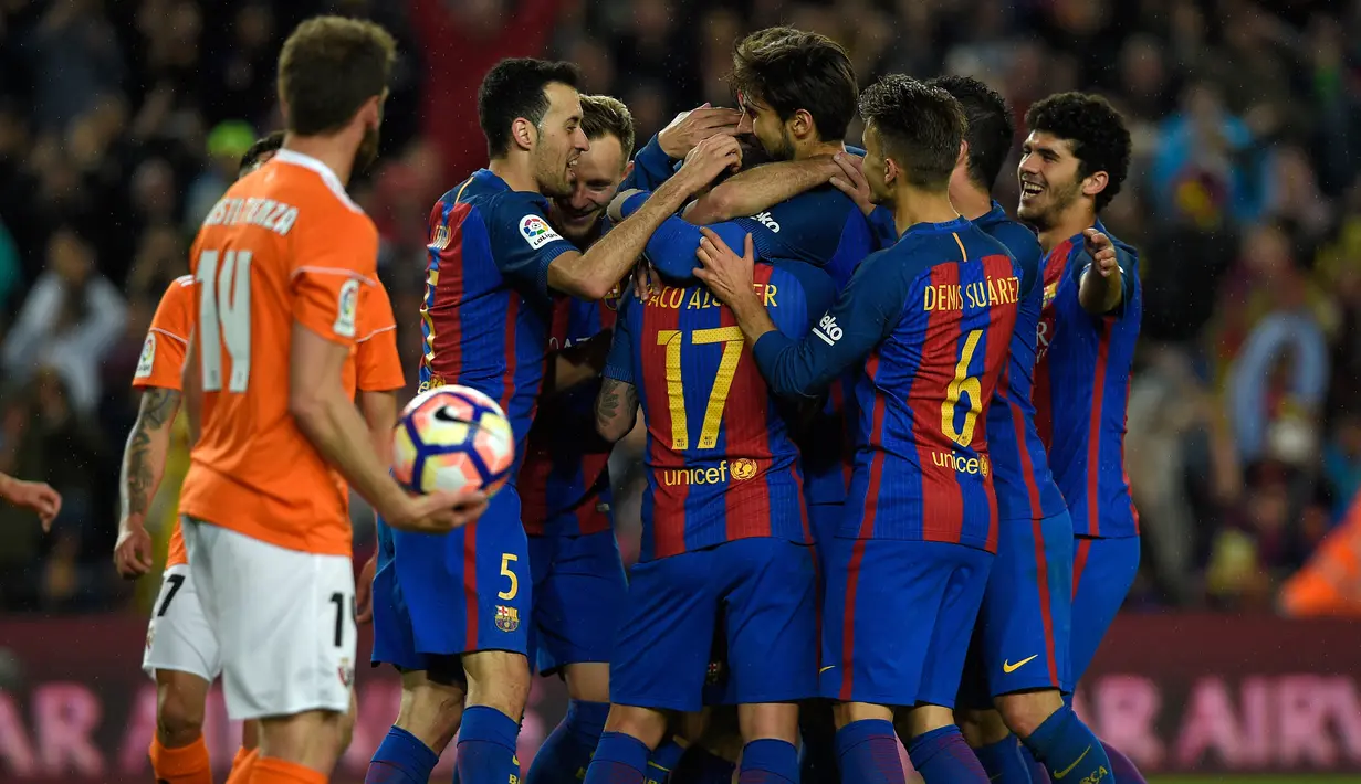 Selebrasi pemain Barcelona usai mencatak gol saat pertandingan liga Spanyol di stadion Camp Nou, Barcelona (26/4). Dengan kemenangan ini, Barcelona tetap menguasai posisi puncak klasemen dengan nilai 78 poin. (AFP/Lluis Gene)