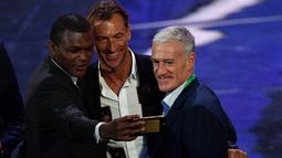 Marcel Desailly, Pelatih Moroko, Herve Renard, dan Didier Deschamps melakukan swafoto saat undian Piala Dunia 2018 di State Kremlin Palace, Moscow, (1/12/2017). Piala Dunia 2018 dimulai sejak 14 Juni-15 Juli 2018 di Rusia. (AFP/Mladen Antonov)
