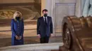 Presiden Prancis Emmanuel Macron (kanan) dan istrinya Brigitte Macron berdiri di depan makam Kaisar Prancis Napoleon (1769-1821) saat upacara peringatan 200 tahun kematiannya di Chapelle Saint-Jerome, Invalides, Paris, Prancis, Rabu (5/5/2021). (Christophe PETIT TESSON/POOL/AFP)