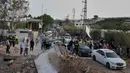 Antrean kendaraan dilaporkan terjadi di jalan-jalan menuju Lebanon Selatan, dengan banyak pengungsi membawa kembali barang-barang mereka. Tampak dalam foto, para pengungsi berjalan kembali ke desa mereka, setelah gencatan senjata antara Hizbullah dan Israel, menyeberangi jembatan Qasmiyeh yang hancur di dekat kota Tyre, Lebanon Selatan, Jumat 17 April 2026. (AP Photo/Mohammed Zaatari)