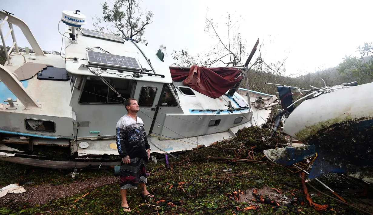Bradley Mitchell memeriksa perahu usai diterjang Topan Debbie di Shute Harbour, Pantai Airlie, Australia, Rabu (29/3). Badai yang mengembuskan angin hingga 161 km per jam memporak-porandakan puluhan bangunan di pesisir. (Dan Peled/AAP Image via AP)