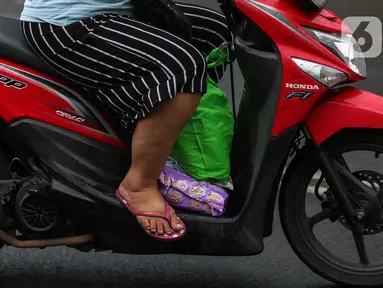 Warga menggunakan sepeda motor melintasi jalan Bintaro Permai, Jakarta, Rabu (15/6/2022). Korps Lalu Lintas (Korlantas) Polri menghimbau kepada masyarakat khususnya pengguna motor untuk tidak menggunakan sandal dan celana pendek saat berkendara dikarenakan,sandal jepit tidak akan melindungi bagian kaki pengendara. (Liputan6.com/Johan Tallo)