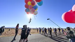 David Blaine terbang dengan memegang balon helium saat melakukan aksi "Ascension" di Page, Arizona, Amerika Serikat, Rabu (2/9/2020). Aksi tersebut mencetak rekor baru sebagai acara langsung YouTube Originals yang paling banyak ditonton. (David Becker/GETTY IMAGES NORTH AMERICA/Getty Images via AFP)