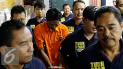 Petugas membawa HK tersangka pembunuhan ibu dan anak di Penggilingan, Cakung, Jakarta Timur dihadirkan saat rilis pengungkapan kasus di Mapolda Metro Jaya, Jakarta, Jumat (16/10/2015). (Liputan6.com/Yoppy Renato)