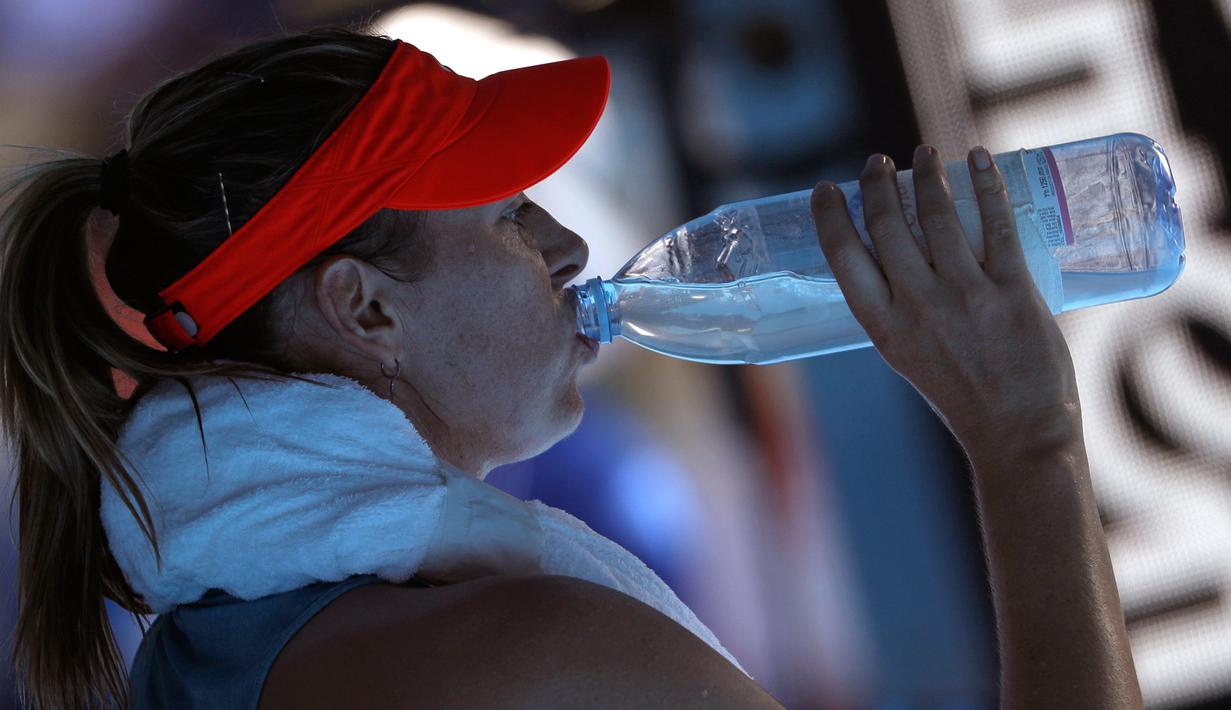 Petenis Rusia Maria Sharapova minum saat pertandingan putaran keempat melawan petenis Australia Ashleigh Barty di kejuaraan tenis Australia Terbuka di Melbourne, Australia(20/1). Sharapova kalah 4-6 6-1 6-4. (AP Photo/Mark Schiefelbein)