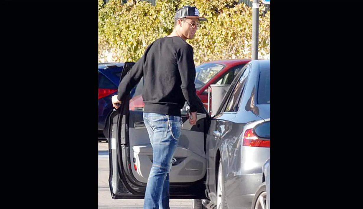 Penyerang Real Madrid Cristiano Ronaldo bersiap menaiki mobilnya saat menjemput anaknya pulang sekolah di Madrid, Selasa (27/1/2015). (Dailymail)