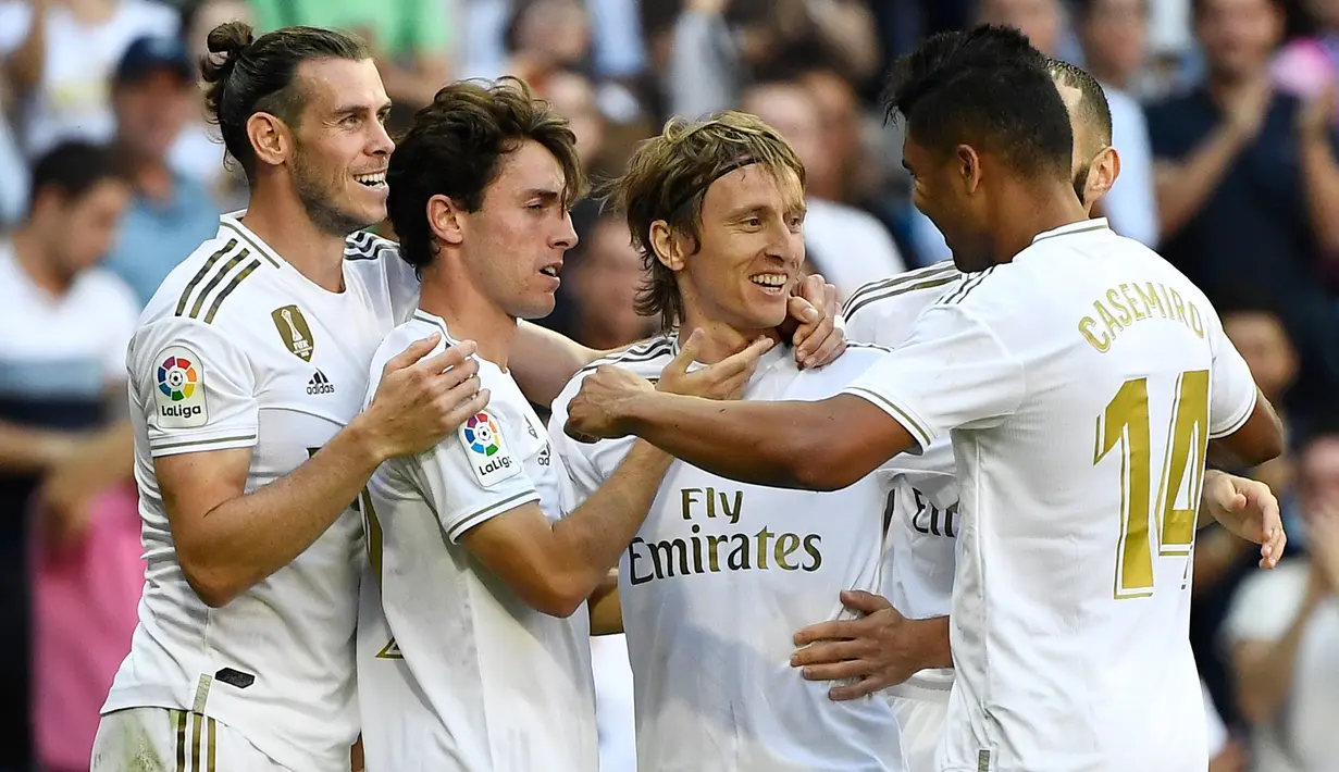 Para pemain Real Madrid merayakan gol yang dicetak Luka Modric pada laga La Liga Spanyol di Stadion Santiago Bernabeu, Madrid, Sabtu (5/10). Madrid menang 4-2 atas Granada. (AFP/Pierre-Philippe Marcou)