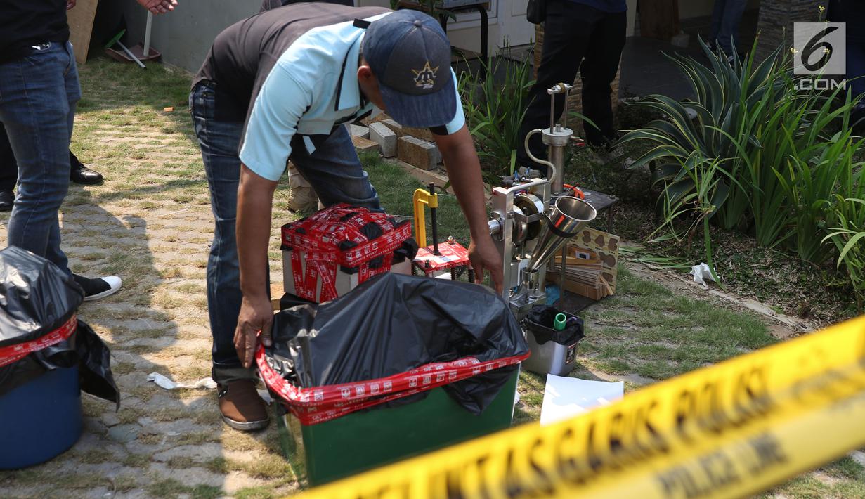 Petugas mengangkut sejumlah barang bukti di sebuah perumahan di Kawasan Pondok Rajeg, Cibinong, Jawa Barat, Senin (24/9). Polisi juga menahan tiga tersangka dan sejumlah barang bukti terkait. (Liputan6.com/Helmi Fithriansyah)