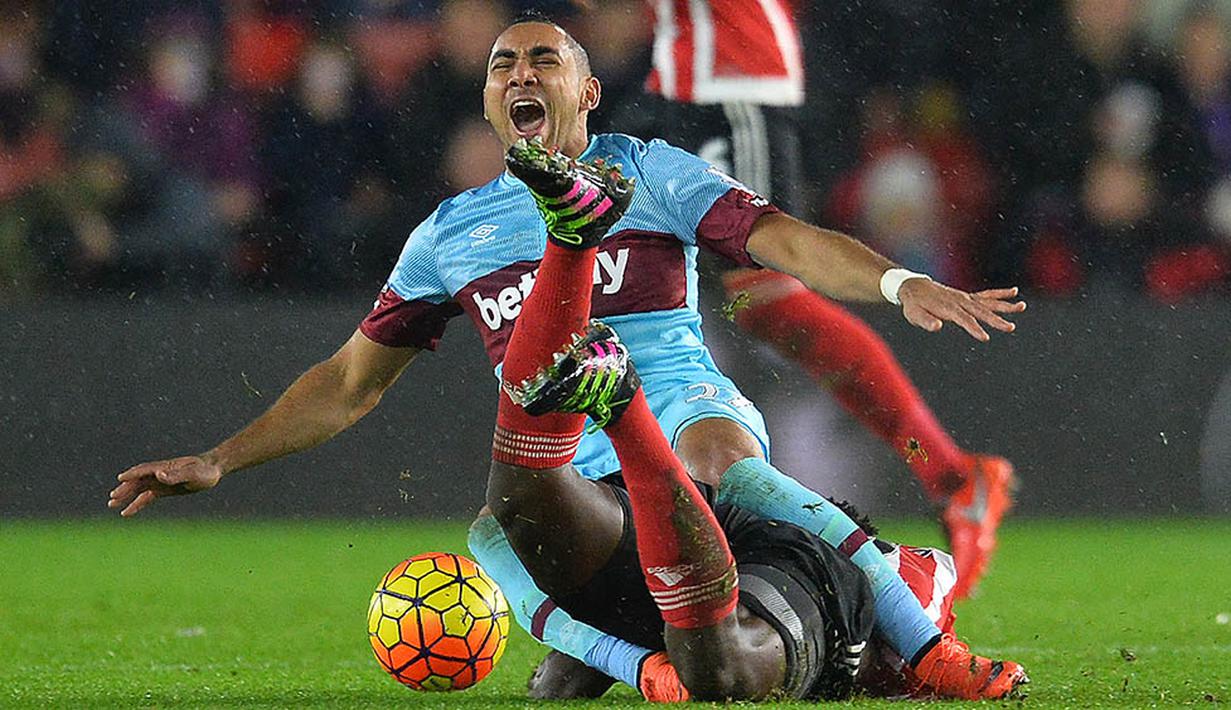 Gelandang Southampton, Victor Wanyama, melakukan tekel keras terhadap pemain West Ham, Dimitri Payet, di Stadion St Mary, Inggris, Sabtu (6/2/2016). Southampton berhasil menang 1-0 atas West Ham. (AFP/Glyn Kirk)
