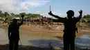 Penjaga Perbatasan Bangladesh (BJB) menghadang warga Rohingya di Ghumdhum, Cox's Bazar, Bangladesh (27/8).  Warga Rohingya berusaha menyelamatkan diri setelah bentrokan antara kelompok ARSA dan militer Myanmar pada Jumat lalu. (AP Photo/Mushfiqul Alam)