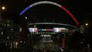 Sejumlah warga beraktifitas di sekitar Stadion Wembley yang dihiasi lampu berwarna bendera Prancis, Senin (16/11/2015). Lampu ini merupakan bentuk belasungkawa Inggris terhadap serangan terror di Paris. (Action Images via Reuters/Henry Browne)