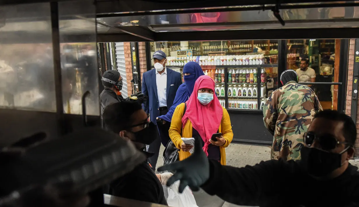 Orang-orang mengantre makan Halal gratis untuk Iftar selama bulan suci Ramadan di depan Masjid Taqwa di Bedford-Stuyvesant, Brooklyn, New York (14/5/2020). Acara ini diorganisir oleh Wakil Advokat Publik Kashif Hussain bersama Presiden Borough Brooklyn, Eric Adams. (Stephanie Keith/Getty Images/AFP)