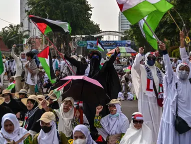 Para pengunjuk rasa melambaikan bendera Palestina dalam sebuah aksi unjuk rasa untuk menunjukkan dukungan kepada rakyat Palestina di Gaza, Surabaya, Jawa Timur pada 19 April 2025. (JUNI KRISWANTO/AFP)