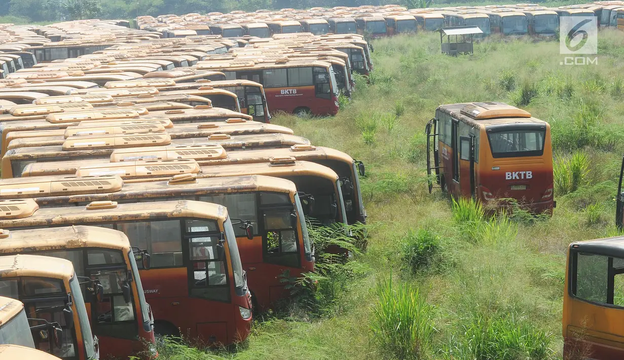 Deretan  bus Transjakarta yang sudah tidak digunakan lagi diparkir di lahan kosong di Dramaga, Kabupaten Bogor, Jawa Barat, Minggu (28/7/2019). Kurang lebih 300 bus Transjakarta dengan kondisi tak terawat diparkir di lahan kosong sejak 2018. (merdeka.com/Arie Basuki)