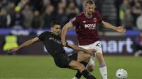 Gelandang Manchester City, Rodri, berupaya merebut bola dari kaki pemain West Ham United, Tomas Soucek, pada laga pekan ke-30 Premier League di London Stadium, Minggu (15/03/2026) dini hari WIB. Sayangnya, Rodri gagal membawa Man City meraih kemenangan, setelah hanya mampu bermain imbang 1-1. (AFP/Ian Kington)