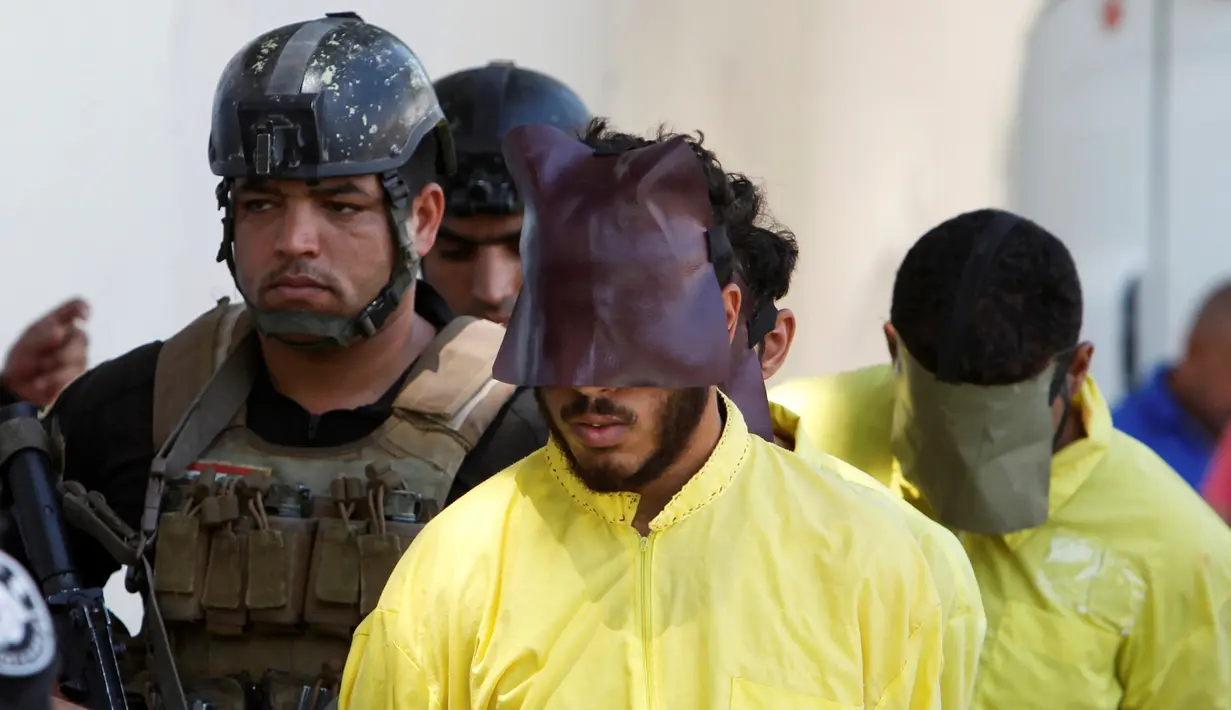 Militer Irak mengawal sejumlah pria yang diduga militan ISIS saat akan konferensi pers di Baghdad, Irak (7/9). Militer Irak menangkap beberapa militan ISIS usai kembali merebut wilayah yang dikuasai. (REUTERS/Khalid al Mousily)