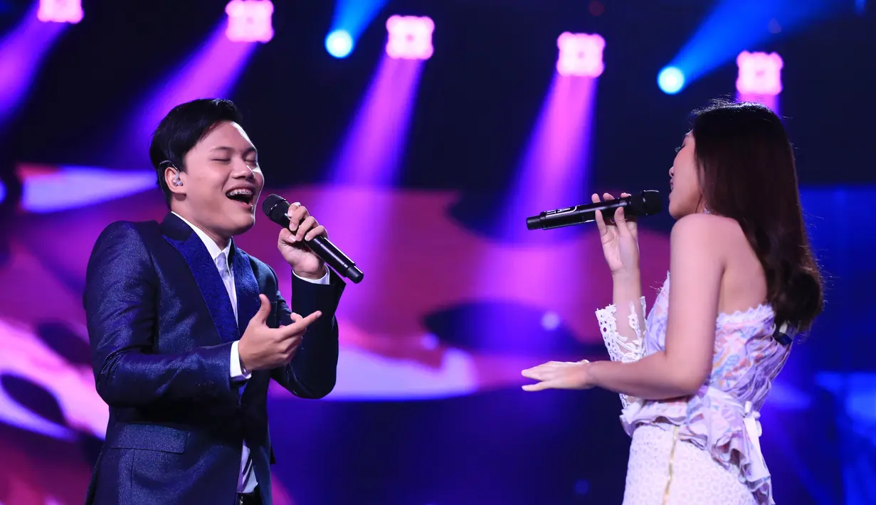 Senyum ceria Isyana mengembang ketika pelantun lagu Kesempurnaan Cinta, Rizky mendekati dan memberikan satu bucket bunga di penghujung aksinya. (Adrian Putra/Bintang.com)