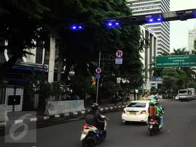 Pengendara melintas di bawah gate ERP di Jalan Jenderal Sudirman Jakarta, Senin (14/12). Meski sudah diuji coba pada pertengahan 2014 lalu, hingga kini penerapan jalan berbayar tersebut masih belum jelas. (Liputan6.com/Helmi Fithriansyah)