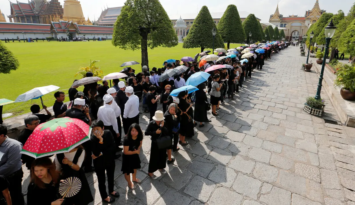 Rakyat Thailand berduka, menghadiri tempat duka Raja Thailand Bhumibol Aduyadej di Bangkok, Jumat (14/10). Pelayat berbaris memasuki Grand Palace untuk memberikan penghormatan terakhir kepada Raja Bhumibol. (Reuters/ Jorge Silva)