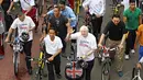 Presiden Joko Widodo bersama Walikota London, Boris Johnson melambaikan tangan saat bersepeda bersama di kawasan Bundaran HI Jakarta, Minggu (30/11/2014). (Liputan6.com/Faizal Fanani)