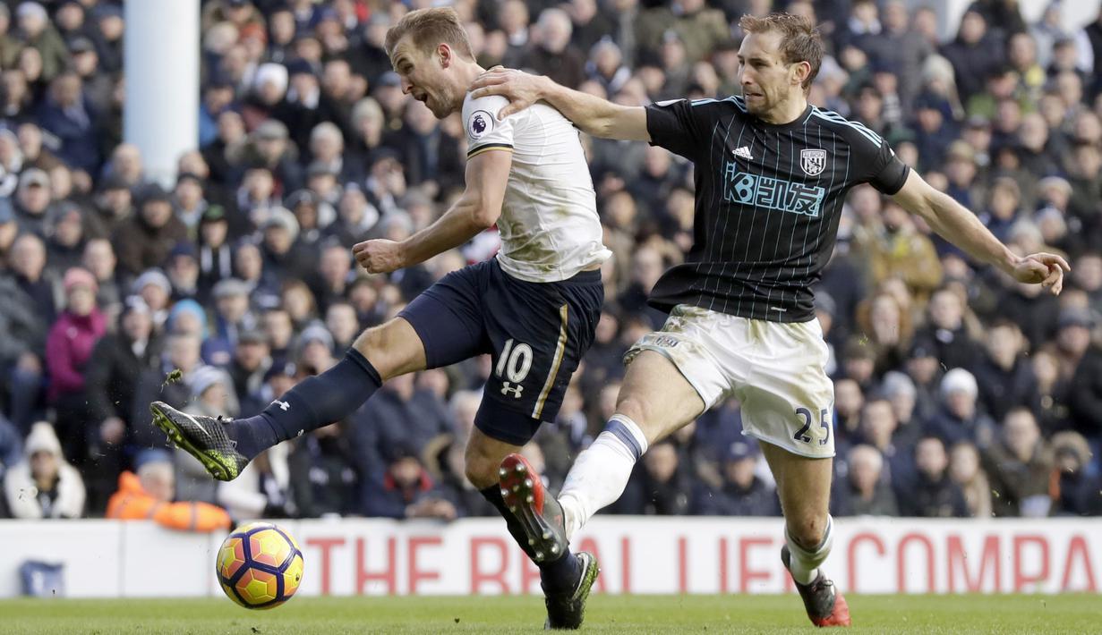 Pemain Tottenham Hotspur, Harry Kane (kiri) melepaskan tembakan saat dihadang pemain West Brom, Craig Dawson pada laga Premier League di White Hart Lane stadium, London, (14/1/2017).  (AP/Matt Dunham)