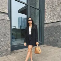 Penampilan ngantor juga bisa chic, seperti terlihat pada Maudy Ayunda. Ia mengenakan tank top putih, dipadu blazer dan celana pendek hitam. Ia memadukan penampilannya dengan alas kaki putih dan menenteng tas tangan berwarna cokelat. [Foto: Instagram/maudyayunda]