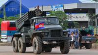 Seorang tentara Kamboja berdiri di atas truk yang membawa peluncur roket BM-21 buatan Rusia yang melaju di sepanjang jalan di Provinsi Oddar Meanchey pada Jumat, 25 Juli 2025. (dok. TANG CHHIN Sothy / AFP)