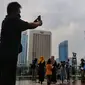 Sejumlah warga berfoto dan antri di anjungan Halte Transjakarta Bundaran HI , Jakarta, Minggu (16/10/2022). Anjungan yang berada di lantai dua Halte Transjakarta Bundaran HI ini dapat menampung 20 orang dan menjadi spat foto baru dengan latar belakang Patung Selamat Datang dan air mancur Bundaran HI. (Liputan6.com/Angga Yuniar)