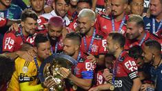 Kapten tim Flamengo Diego (kiri) mencium trofi disaksikan rekan satu timnya usai menjuarai Liga Brasil di Sao Paulo, Kamis (25/2/2021). (Foto: AFP/Nelson Almeida)