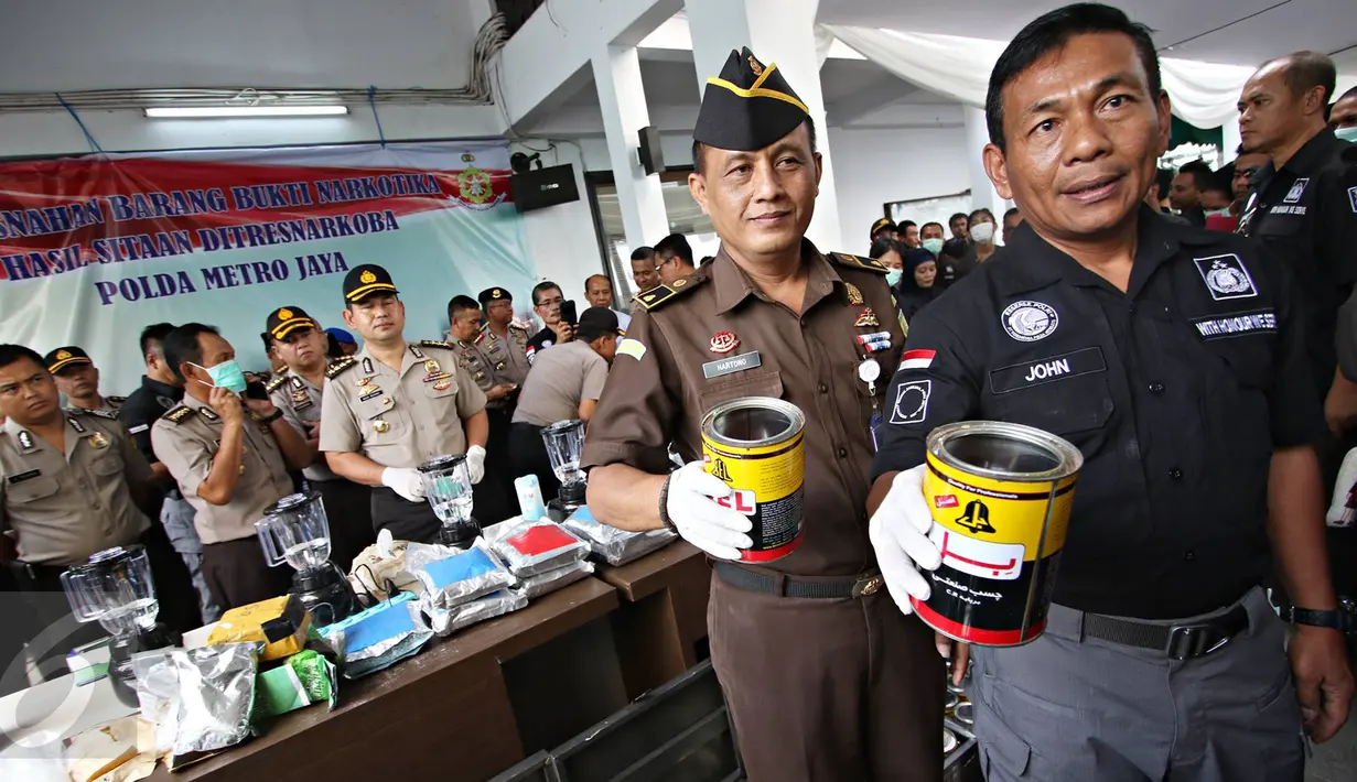 Dirnarkoba Polda Metro Jaya Kombes Pol John Turman menunjukkan sabu cair yang diseludupkan dalam kaleng lem, saat pemusnahan barang bukti narkoba berupa sabu cair, sabu kristal dan ekstasi di Jakarta, Kamis (16/6). (Liputan6.com/Immanuel Antonius)